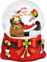 Sneeuwbol vrolijke kerstman met Zak vol pakjes en cadeautje in de hand op rode sokkel 9cmHxØ7.5cm