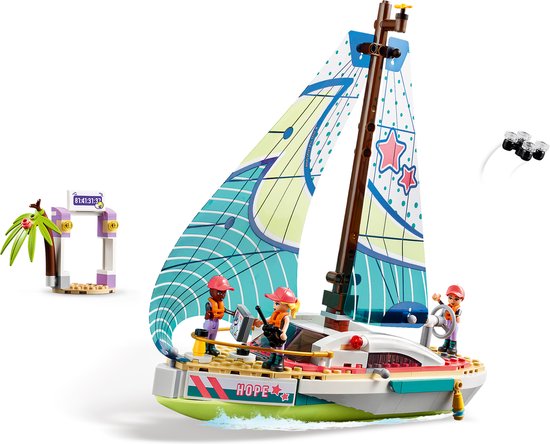 LEGO Friends zeilboot met drie poppetjes, met een racepoort en palmboom ernaast.