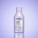 Flacon violet de 300 ml de Redken Blondage High Bright Conditioner, avec formule équilibrée au pH.