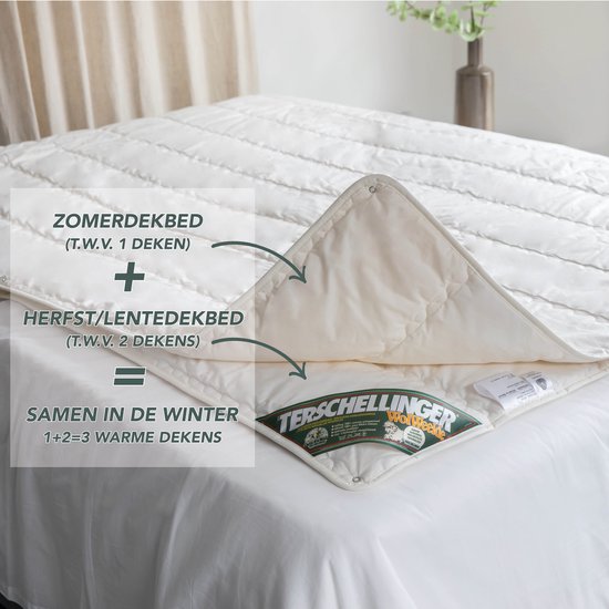Wit katoenen dekbed, opgemaakt als twee aparte dekens die samen één winterdeken vormen. Met labels en logo.