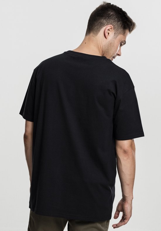 Man, gezicht naar achteren, draagt een zwart oversized T-shirt met korte mouwen.