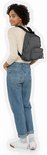 Vrouw met donkergrijze Eastpak Orbit rugzak in denimlook, gedragen.