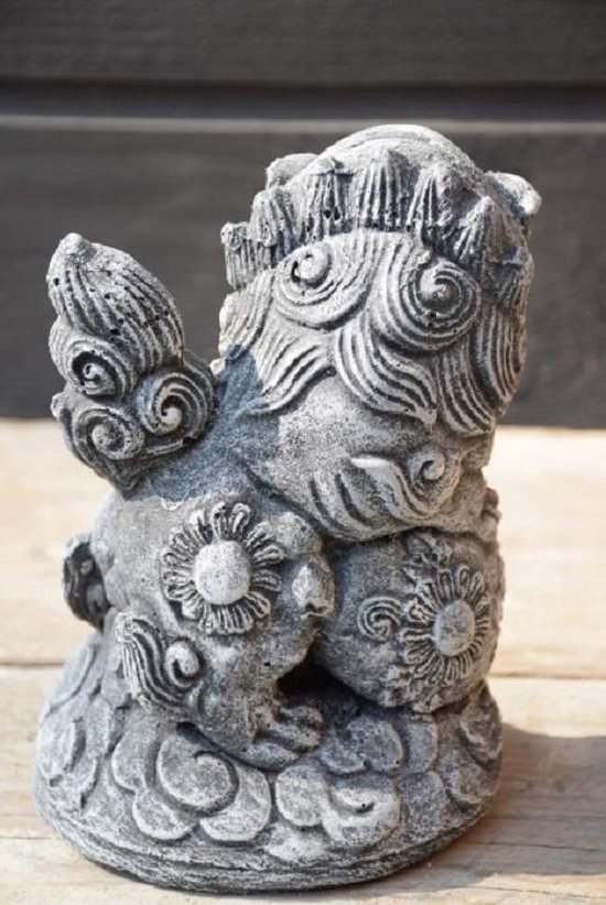 Grijze stenen foo dog tuinbeeld, zittend, bloemenmotief op lichaam, van achteren gezien.