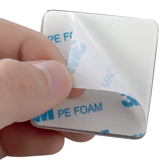 Main révélant le dos carré adhésif d'un crochet avec le texte 'PE FOAM'.