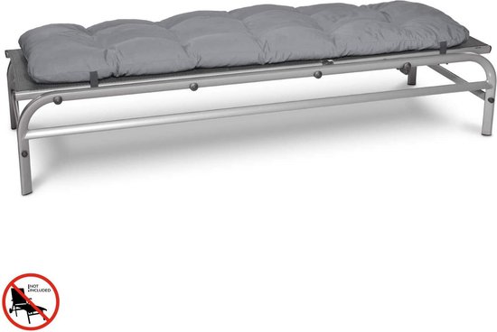 Een zilverkleurig metalen frame bed met een dik grijs kussen erop.