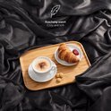 Een donkergrijze fleece deken bedekt met een dienblad met koffie en croissant. Zacht en comfortabel.