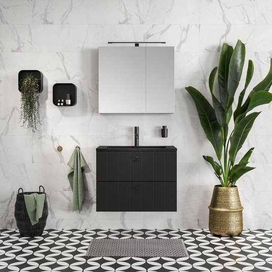 Salle de bain moderne avec carrelage noir et blanc, meubles noirs et accessoires dorés.