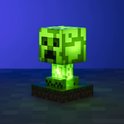 Een felgroene Minecraft Creeper-lamp, gloeiend met intern licht, staand op een gras- en aarde-voetstuk.