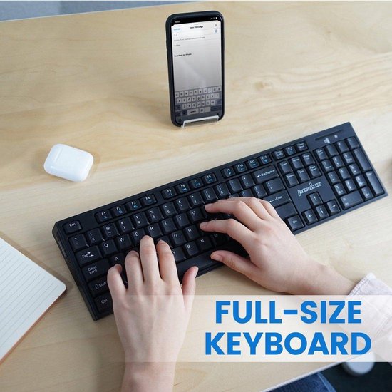 Een persoon typt op een zwart, full-size Bluetooth toetsenbord, met een telefoon op standaard ernaast.