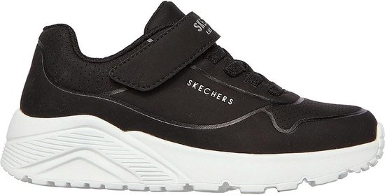 Sneaker Skechers noire avec fermeture velcro et semelle blanche. Perforations sur le côté.