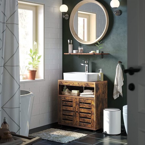 Bruin badmeubel met wastafel en spiegel, omringd door badkameraccessoires.