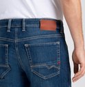 Detail van de achterkant van een blauwe MAC Jeans met bruin label en rood detail op de zak.