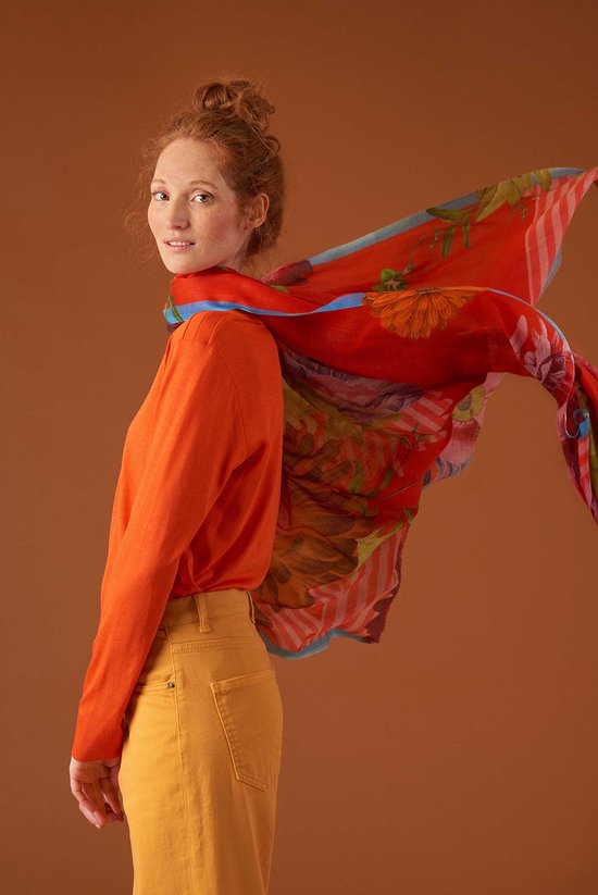 Mannequin portant un t-shirt Oillily orange, un pantalon jaune et une écharpe orange à imprimé floral.