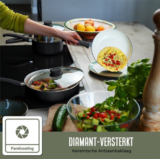 Vrouw in groene blazer haalt omelet uit witte koekenpan met diamant-versterkte keramische antiaanbaklaag.