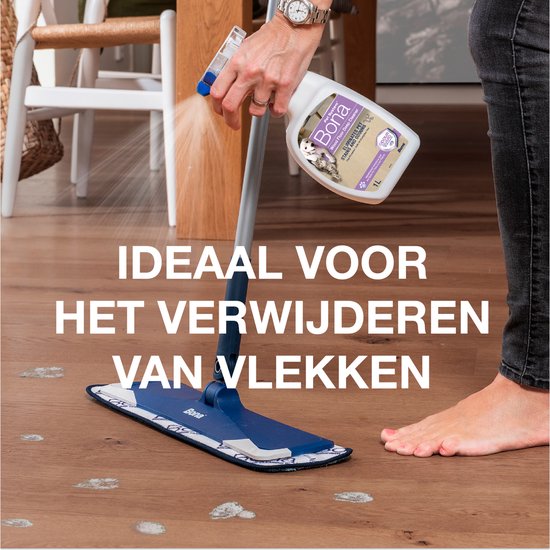 Hand spuit Bona reinigingsmiddel op een houten vloer met vlekken. Dweil is dichtbij. Tekst: "Ideaal voor het verwijderen van vlekken".