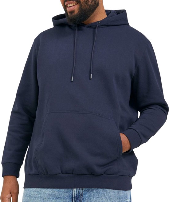 Man met dreadlocks en baard, gekleed in een donkerblauwe hoodie met trekkoord, met de hand in de zak.