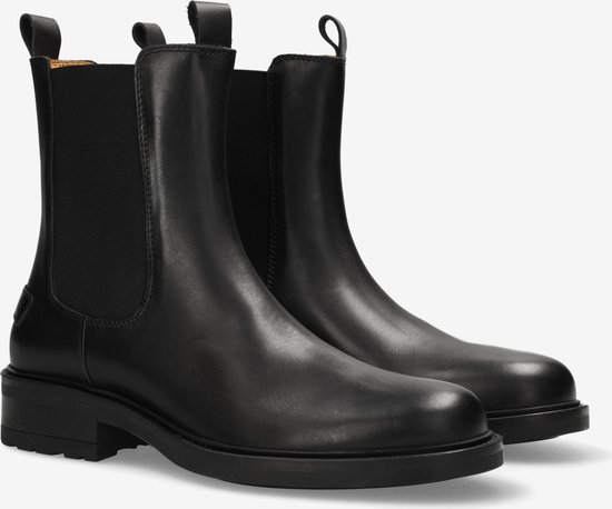 Paar zwarte leren chelsea boots met elastische zijkanten, zijkant zichtbaar.