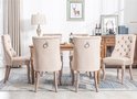 Achterkant van beige fluwelen eetkamerstoelen met hoge rugleuning en ringdetail.