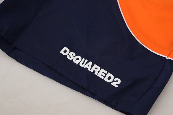 Marineblauwe zwembroek met oranje accenten, witte bies en witte 'DSQUARED2' opdruk.