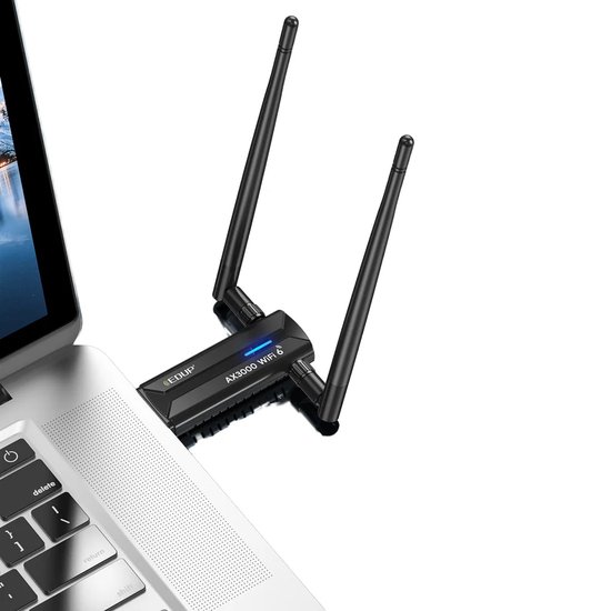 Zwarte EDUP WiFi 6E adapter met twee zwarte antennes, aangesloten op een laptop. Blauwe LED licht op.