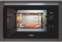 Inbouwmagnetron met open deur, een stuk zalm op een schaal erin. Links de Whirlpool logo.