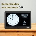OER dementieklok met een zwart frame, dat de datum 'woensdag 9 juni 2021' en tijd weergeeft op een houten tafel.
