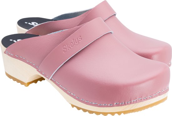 Close-up van pastelroze Skolys klompen met houten zool en rubberen zool. Leren bandje met merkembleem.