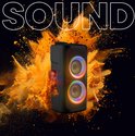 Zwarte party speaker met dubbele woofers en gekleurde lichten, omringd door oranje poeder explosie.