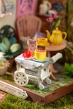 Close-up van miniatuur dienblad met gebak, aardbeien en snoep.