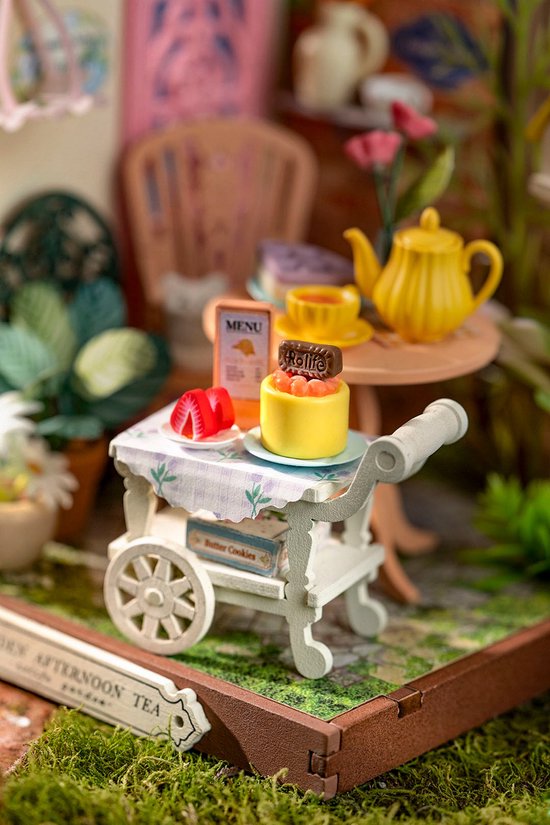 Close-up van miniatuur dienblad met gebak, aardbeien en snoep.