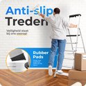 Man schildert een muur vanaf een aluminium huishoudtrap met antislip treden en rubberen pads.