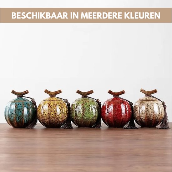 Vijf keramieken urnen in verschillende kleuren: groen, geel, blauw, rood en beige, met kwastjes.