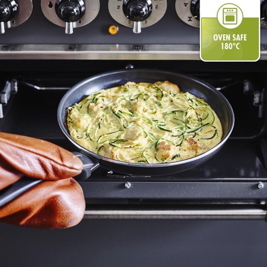 Une poêle avec une omelette aux légumes est retirée d'un four à l'aide de maniques. Logo "OVEN SAFE 180°C".