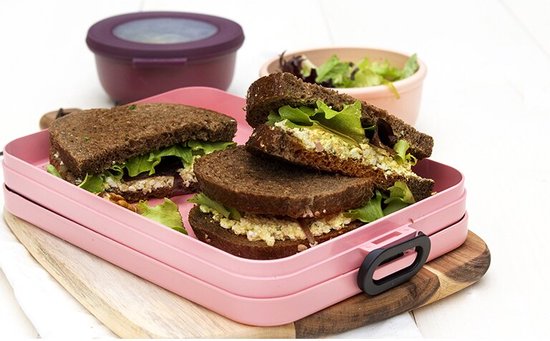 Roze Mepal lunchtrommel met twee belegde broodjes, komkommer en cherrytomaten.