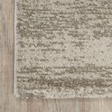 Tapis beige avec un subtil motif quadrillé, posé sur un parquet.