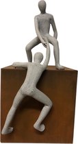sculptuur man helpende hand op cortenstaal kubus