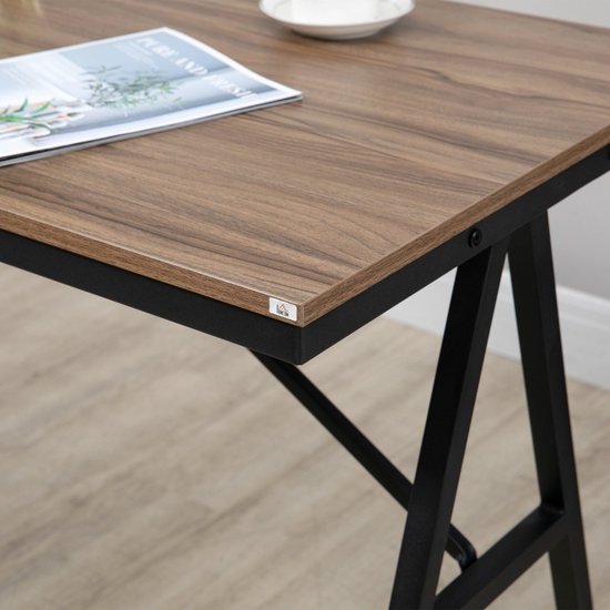Close-up van het walnoothouten tafelblad met zwart metalen frame.