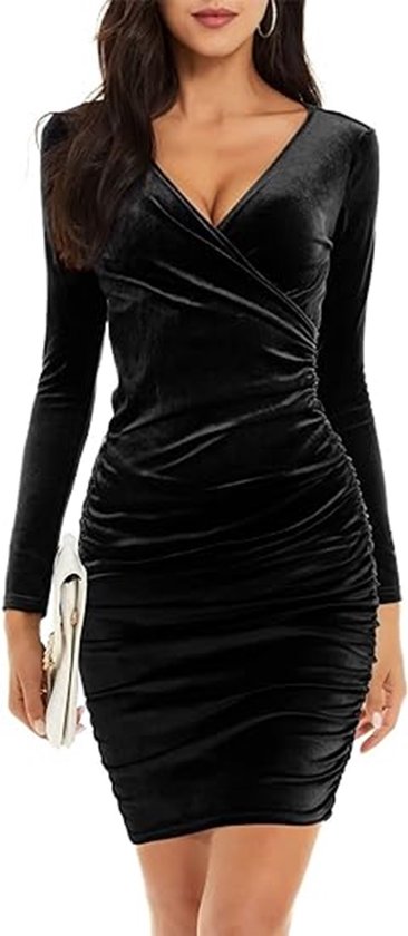 Robe portefeuille noire en velours à manches longues, fronces sur le côté et décolleté en V. Le mannequin tient une pochette blanche.
