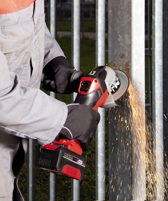 Man gebruikt een rode en zilverkleurige haakse slijper met vonken op een metalen hek.