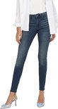 Model in een skinny spijkerbroek met middelhoge taille.