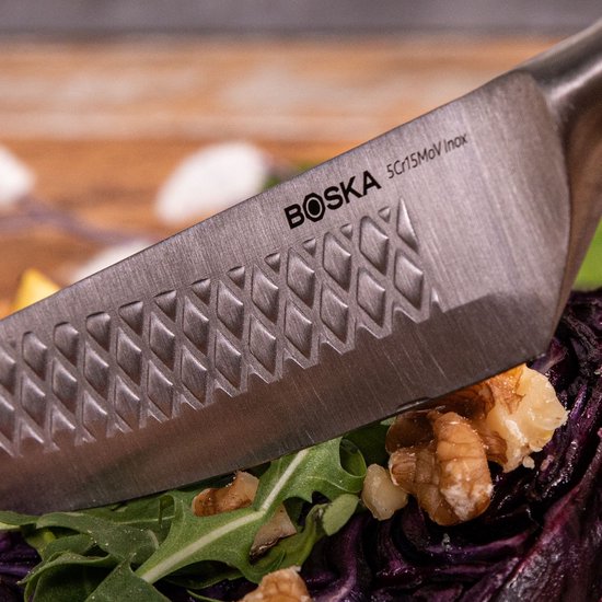 Boska RVS steakmes met geperforeerd lemmet en houten handvat snijdt rode kool.