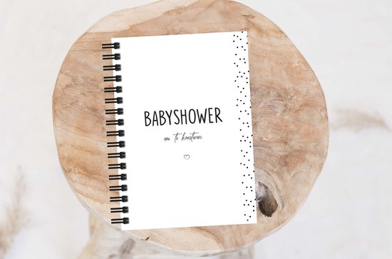 Een babyshower invulboek met de tekst 'Babyshower om te koesteren'. De kaft is wit met zwarte stippen.