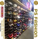 Mur avec diverses casquettes de différentes couleurs et designs, vendues en magasin.
