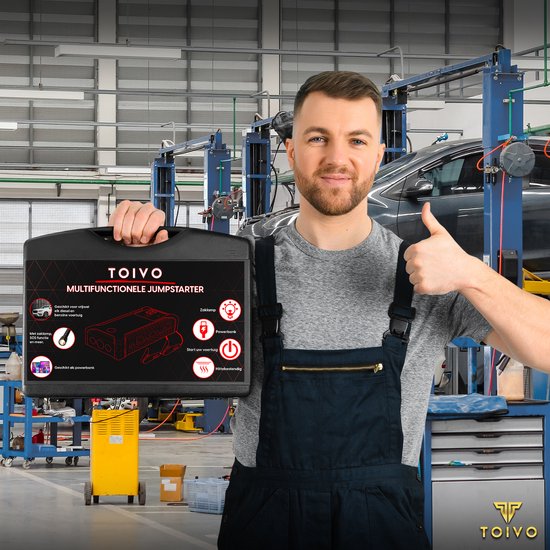 Monteur met jumpstarter koffer en duim omhoog in werkplaats.