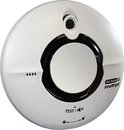Witte, ronde Wi-Safe 2 FireAngel rookmelder met zwarte ring. 'TEST/AV' en 'WAARSCHUWING: Batterij niet vervangbaar'.