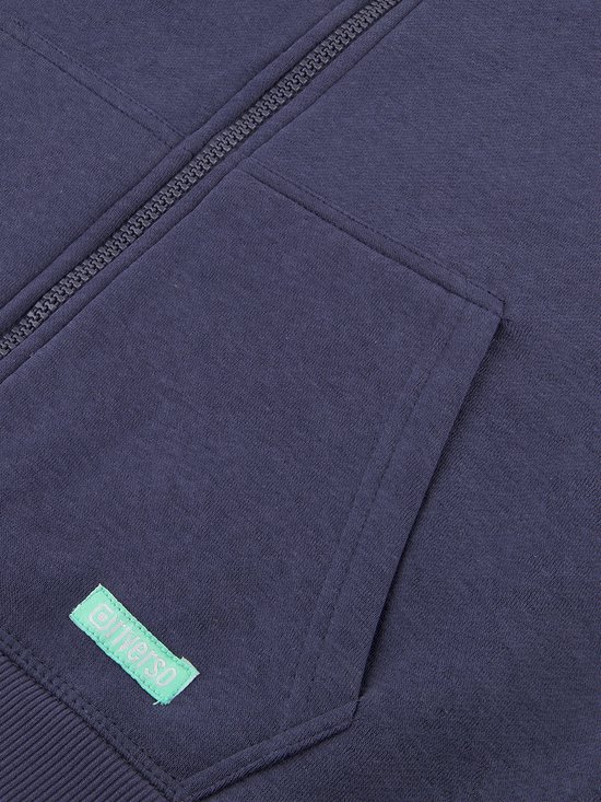 Detail van de zak en het label van een donkerblauwe sweater.