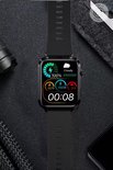 Zwarte smartwatch met een zwart bandje, toont een startscherm met 100% batterij, stappen, afstand en tijd.