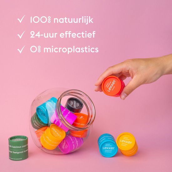 Een hand pakt een fel oranje potje Lekker deodorant uit een glazen pot gevuld met diverse Lekker deodorants.