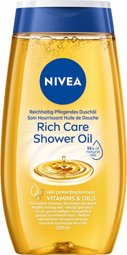 Een gele fles NIVEA Shower Oil ligt op een beige ondergrond, omringd door druppels olie. Tekst op de fles en links.