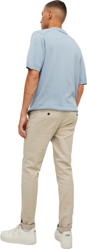 Man met korte mouwen lichtblauwe polo en beige chino.